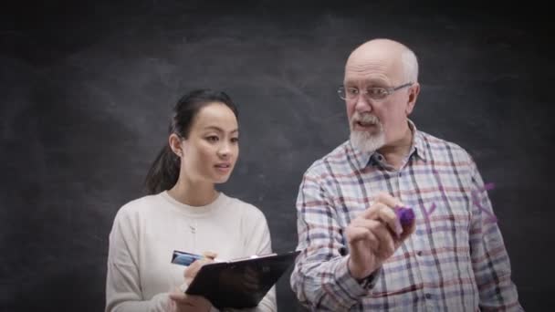 Άνδρας και γυναίκα γράφοντας μαθηματικοί τύποι — Αρχείο Βίντεο