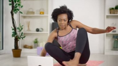 bir dizüstü bilgisayar kullanan kadın bir egzersiz izleyin