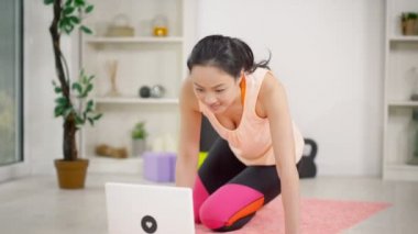 bir dizüstü bilgisayar kullanan kadın bir egzersiz izleyin