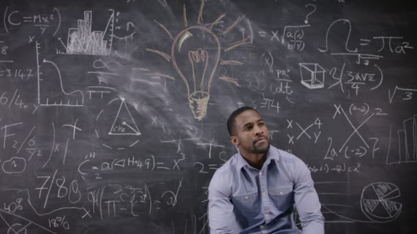 Man sitting in front of blackboard — Stock Video