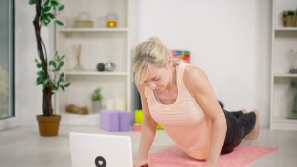 Woman using a laptop follow a workout — Stock video