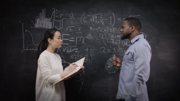 Man and woman writing math formulas — Stock Video