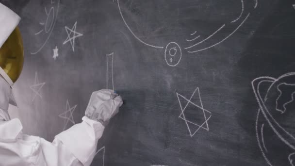 Astronaut schrijven op blackboard — Stockvideo