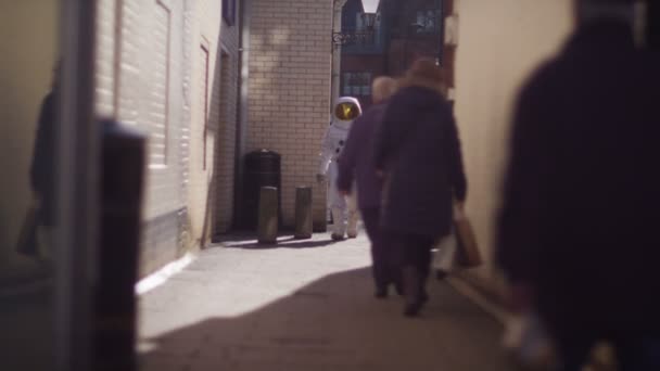 Astronaut walking through street — Stockvideo