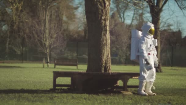 Astronaut verloren in een park — Stockvideo