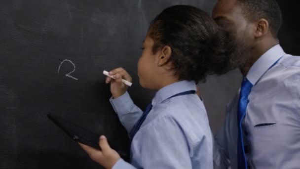 Hombre y niño escribiendo en pizarra — Vídeos de Stock