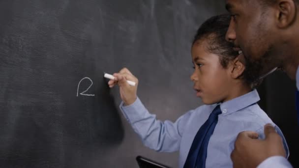 Mężczyzna i chłopiec pisanie na tablicy — Wideo stockowe