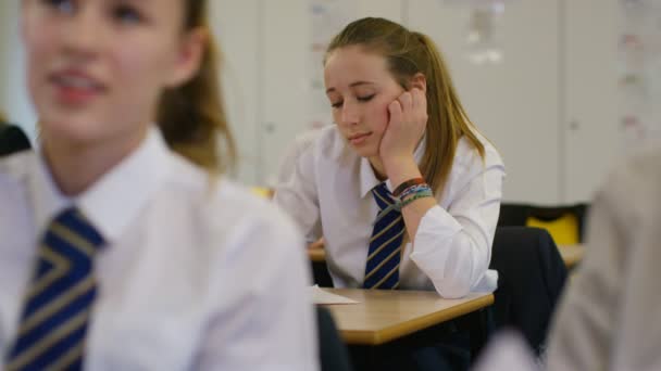 Gelangweiltes Mädchen sitzt am Schreibtisch — Stockvideo