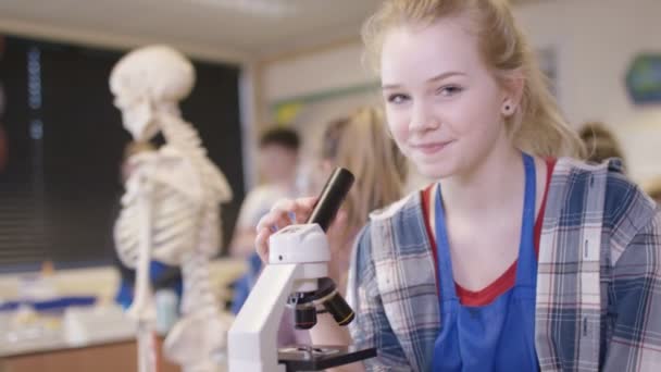 Девушка с микроскопом в школе — стоковое видео