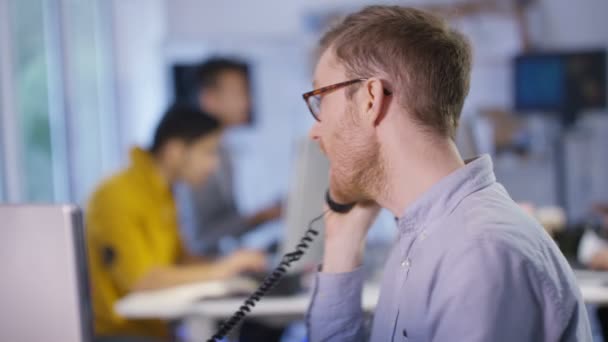 Бизнесмен разговаривает по телефону в офисе — стоковое видео