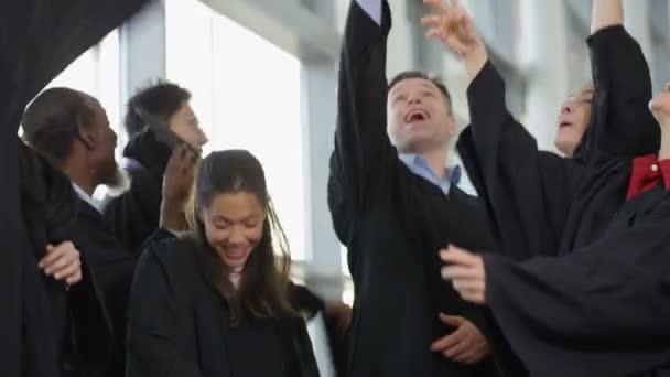 Estudiantes lanzando gorras al aire — Vídeo de stock