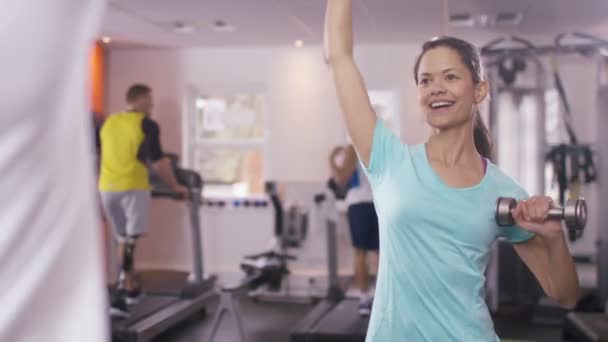 Vrouw uit te werken met personal trainer — Stockvideo