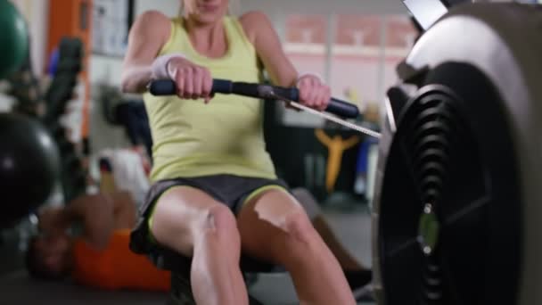 Mujer haciendo ejercicio en máquina de remo — Vídeos de Stock