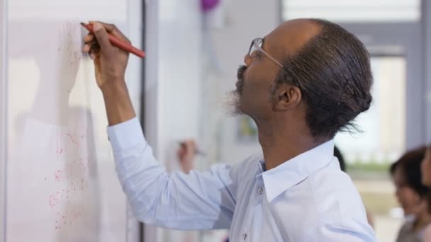 Muž píše na tabuli v úřadu — Stock video