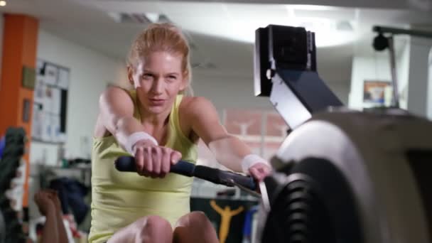 Woman working out on rowing machine — Stock Video