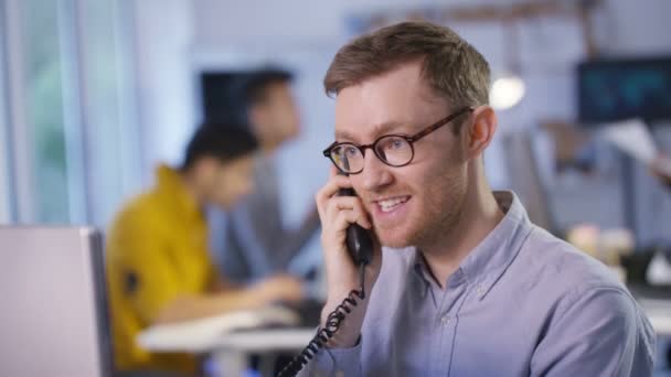 Zakenman aan de telefoon aan het praten op kantoor — Stockvideo