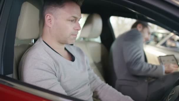 Продавец показывает покупателю интерьер нового автомобиля — стоковое видео