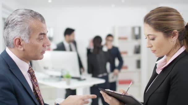 Empresario dando instrucciones a asistente — Vídeo de stock