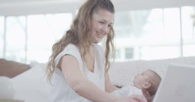 dizüstü bilgisayarda çalışan anne holding bebek