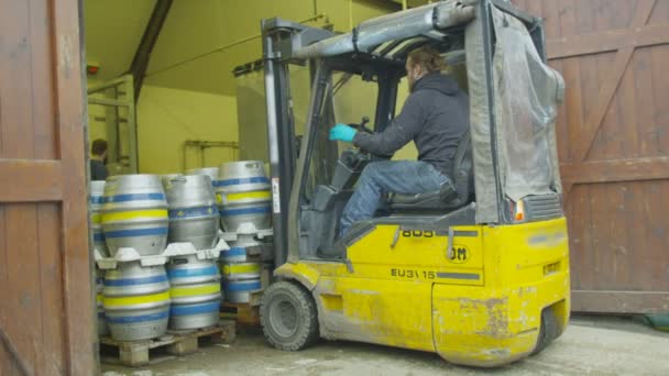 Worker using a forklift truck to transport barrels — Stock Video