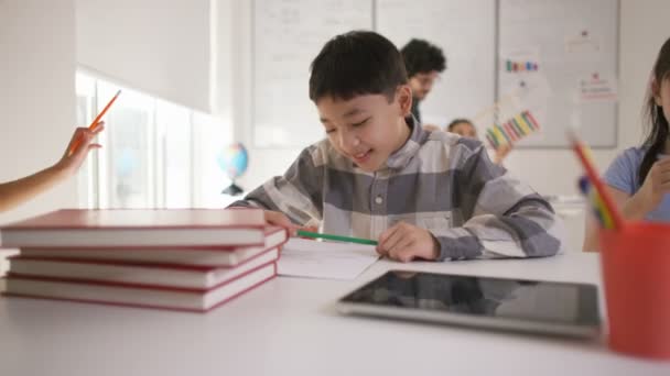 Niño pequeño trabajando en su escritorio — Vídeos de Stock