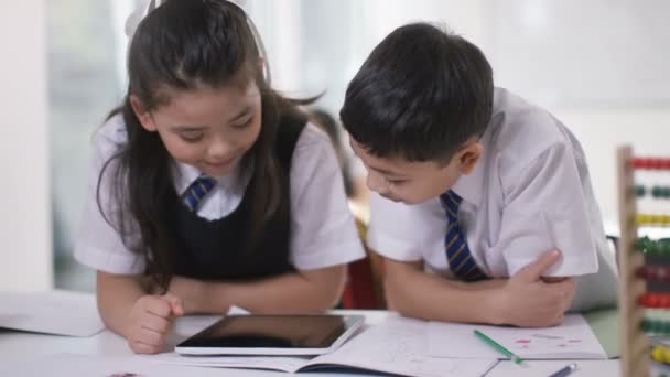 Niño y niña trabajando en la tableta de ordenador — Vídeo de stock