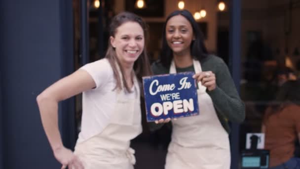 Kvinnor utanför café håller upp en skylt — Stockvideo