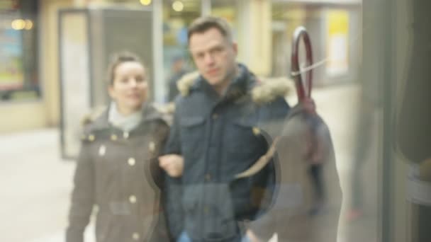 Пара смотрит в окно магазина одежды — стоковое видео