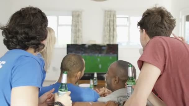 Друзья смотрят спортивную игру по телевизору — стоковое видео