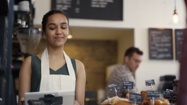 Trabajador que atiende a un cliente en tienda — Vídeo de stock