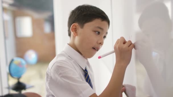 School jongen in de klas luisteren naar leraar — Stockvideo