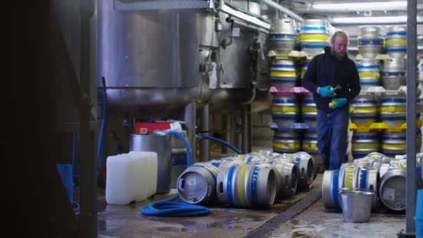 Рабочий, готовящий бочки пива — стоковое видео