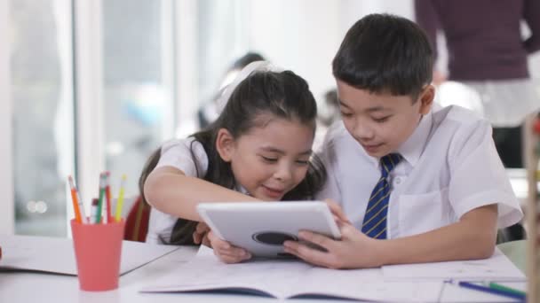 Мальчик и девочка, работающие за компьютером — стоковое видео
