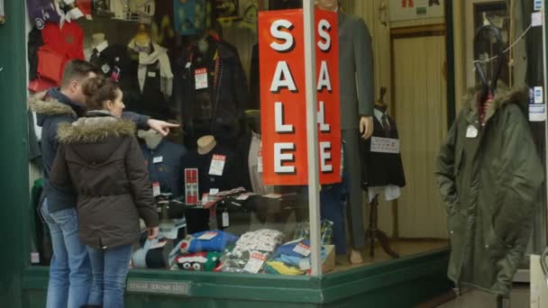 Koppel op zoek in het venster van kledingwinkel — Stockvideo