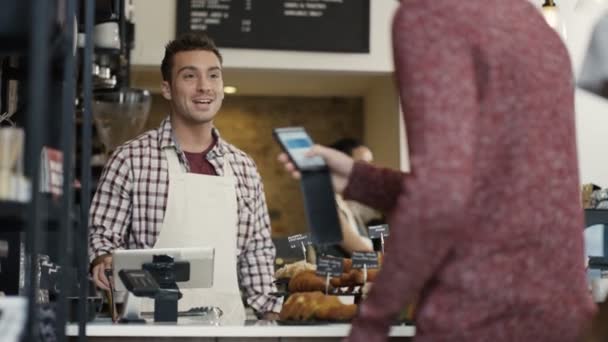 Trabajador que atiende a un cliente en tienda — Vídeo de stock