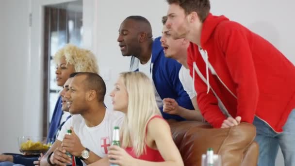 Друзья смотрят спортивную игру по телевизору — стоковое видео