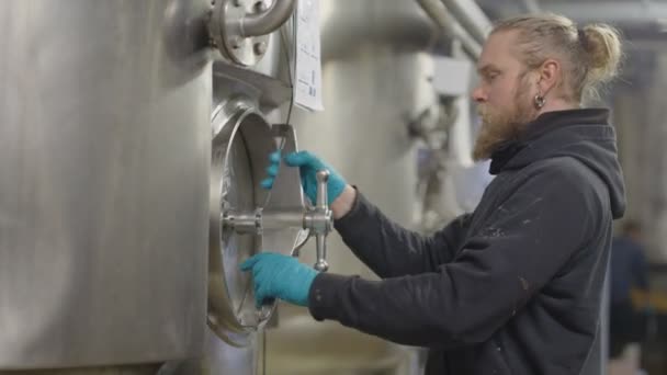 Werknemer in een brouwerij controleren de machines — Stockvideo