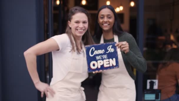 Mujeres fuera de la cafetería sostienen un cartel — Vídeos de Stock