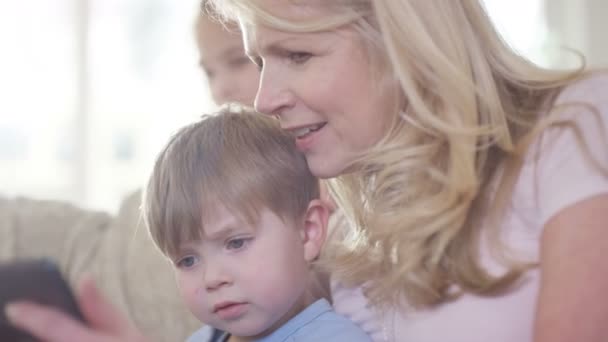 Mutter und Kinder schauen auf Tablet — Stockvideo