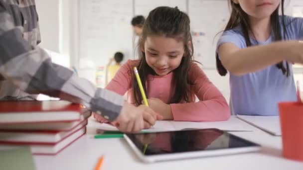Щаслива маленька дівчинка працює за її столом — стокове відео