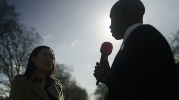 Woman giving live interview to reporter — ストック動画