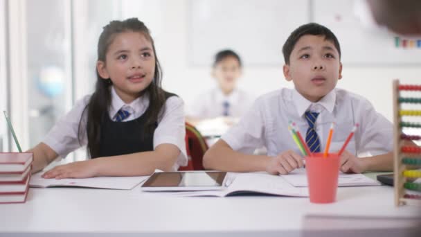 Escolares en clase escuchando a la maestra — Vídeo de stock