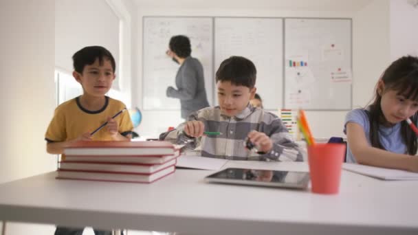 Niño pequeño trabajando en su escritorio — Vídeos de Stock