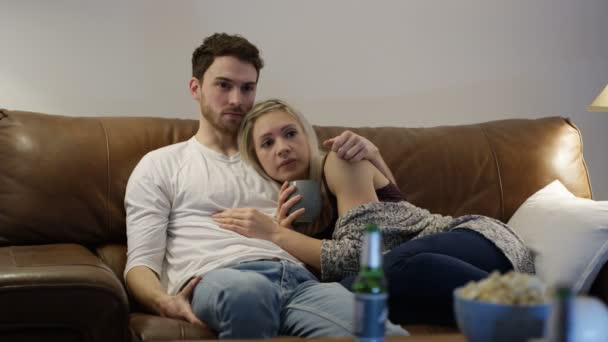 Пара реагирует на что-то страшное на ТВ — стоковое видео