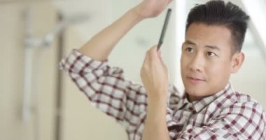 Adam saçını tarıyor.