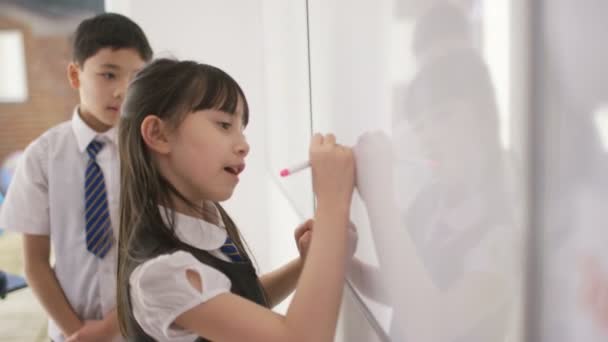 Escolares en clase escuchando a la maestra — Vídeos de Stock