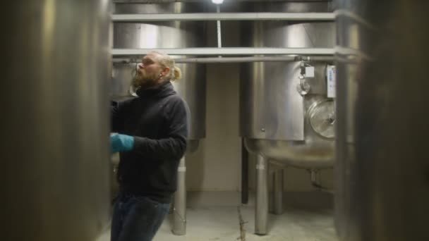 Werknemer in een brouwerij controleren de machines — Stockvideo