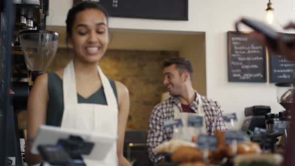 Trabajador que atiende a un cliente en tienda — Vídeo de stock