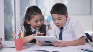 erkek ve kız bilgisayar tablet üzerinde çalışan