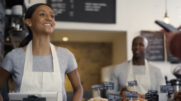 Trabajador que atiende a un cliente en tienda — Vídeo de stock